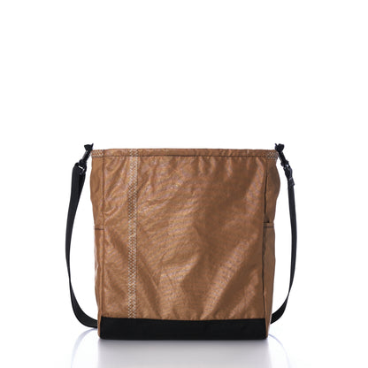 Vintage Caramel Tanbark Voyager Medium Crossbody bag in caramel tanbark with a black base and an adjustable black shoulder strap.