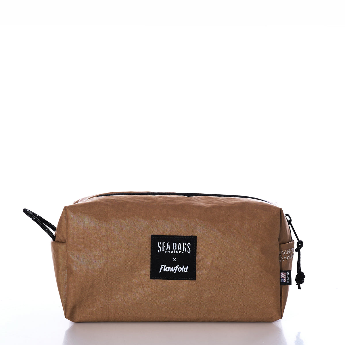 Vintage Caramel Tanbark Toiletry Bag made from caramel-colored recycled sail cloth with a black “Sea Bags x flowfold” label on the front.