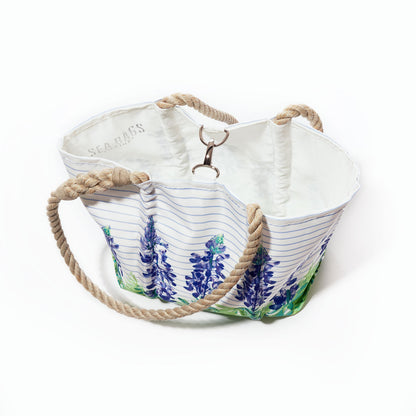 Introducing the Lupine Sailor Stripe Handbag by Sea Bags—a spacious coastal tote crafted from recycled sail cloth, featuring bold stripes, floral prints, a white interior, and sturdy rope handles for both style and sustainability. by Sea Bags