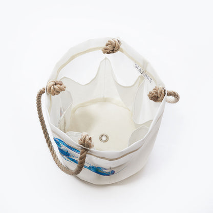 The Multicolor Lobster Beverage Bucket by Sea Bags is a white canvas bucket bag made from recycled sail cloth, featuring rope handles, a metal eyelet at the bottom, and a vibrant lobster design—perfect as a stylish beverage tote—shown from above against a white background. by Sea Bags