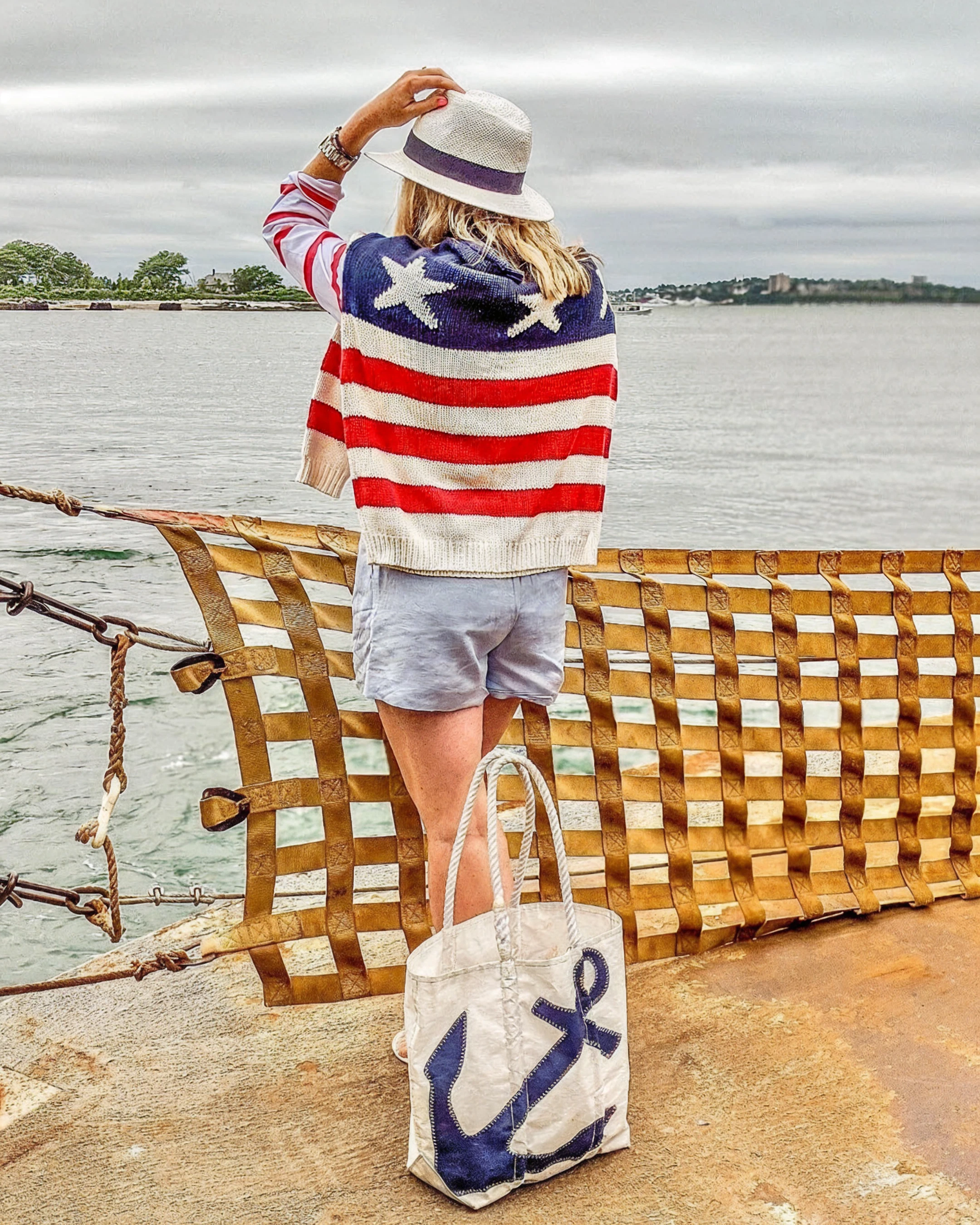 Woman wearing a stars and stripes sweater next to a Sea Bags Navy Anchor Tote