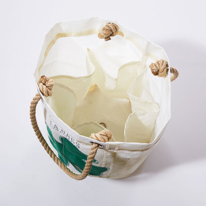 Sea Bags’ Four Leaf Clover Beverage Bucket Bag, made from recycled sail cloth, features sturdy rope handles, interior pockets, and a green four-leaf clover graphic on the exterior; shown open from above against a plain background. by Sea Bags