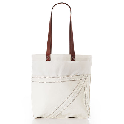 Sea Bags Market Tote in white canvas features brown leather shoulder straps, a leather handle, and prominent diagonal stitching on the front pocket, displayed against a white background. by Sea Bags