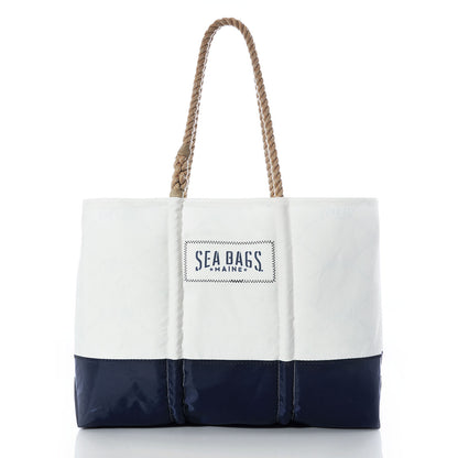 Sailmaker’s Tote with Clasp and Hanging Pocket by Sea Bags, crafted from recycled sail cloth in white and navy with rope handles and a Sea Bags label on the front, shown against a white background. by Sea Bags
