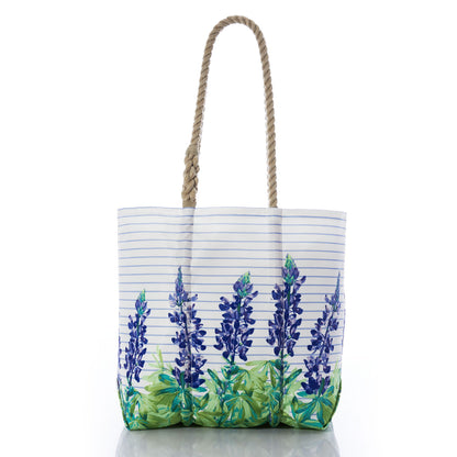 The Sea Bags Lupine Sailor Stripe Medium Tote, crafted from recycled sail cloth, features blue and green floral designs with blue horizontal stripes and two thick twisted rope handles—perfectly capturing true coastal charm. by Sea Bags