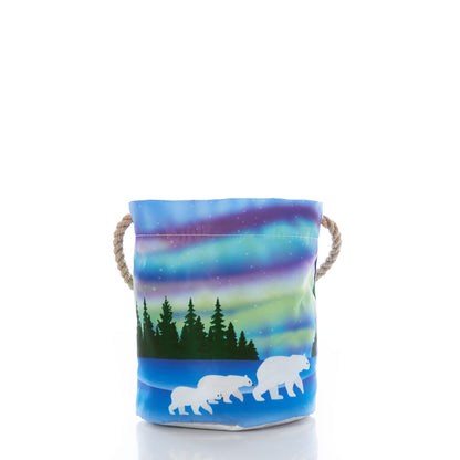 Introducing the Northern Lights Bucket Bag by Sea Bags—a small bucket crafted from recycled sail cloth with rope handles, featuring artwork of a polar bear family beneath trees and a vibrant northern lights sky. by Sea Bags