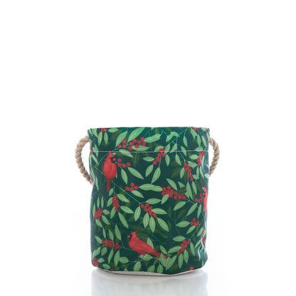 Sea Bags’ Winterberry Cardinals Bucket Bag, crafted from sustainable materials and adorned with a cardinal and leaf print, features two rope handles on each side—perfect for holiday decor and pictured against a white background. by Sea Bags