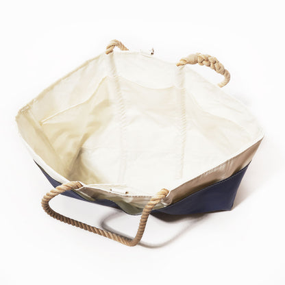 The Sea Bags Breton Stripe Whale Ogunquit Beach Tote is a large, open nautical bag made from recycled sail cloth, showcasing a navy blue exterior with classic Breton stripes, a crisp white interior, and sturdy twisted rope handles. Shown on a white background, this eco-friendly tote is perfect for seaside adventures. by Sea Bags