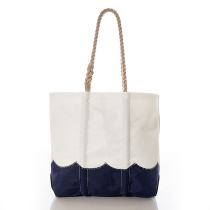 Sea Bags Wavy Seas Medium Tote, crafted from durable recycled sail cloth, features a thick rope handle and a navy blue scalloped bottom edge, shown against a white background. by Sea Bags