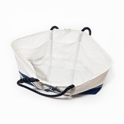 The Sea Bags Dallas Cowboys Tailgate Tote—a large, white and blue tote bag with black rope handles—is pictured from above, revealing its spacious, empty interior against a white background. Expertly crafted from recycled sail cloth, this stylish and durable accessory is the perfect choice for football fans. by Sea Bags