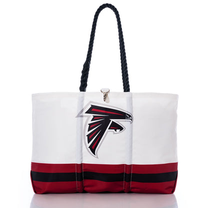 Flaunt your team pride with the Atlanta Falcons Tailgate Tote by Sea Bags, expertly crafted from recycled sail cloth. This chic white tote showcases durable black handles, the iconic Atlanta Falcons NFL logo, and striking red and black stripes along the bottom—all beautifully captured on a clean white backdrop. by Sea Bags