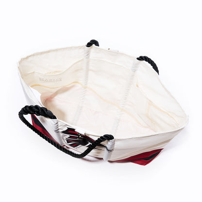 Open white Atlanta Falcons Tailgate Tote by Sea Bags featuring black rope handles, red and black exterior detailing, and a visible Sea Bags label on the inner lining against a white background—crafted from recycled sail cloth for a durable and eco-friendly NFL logo bag. by Sea Bags