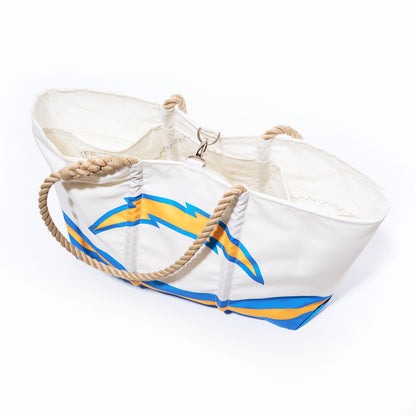 Carry your essentials in style with the Los Angeles Chargers Tailgate Tote from Sea Bags—a white canvas bag showcasing a bold yellow and blue lightning bolt design. Featuring thick twisted rope handles and a secure metal clasp inside, this versatile tote combines sturdy construction with team spirit, making it perfect for everyday use or cheering on your favorite team. by Sea Bags
