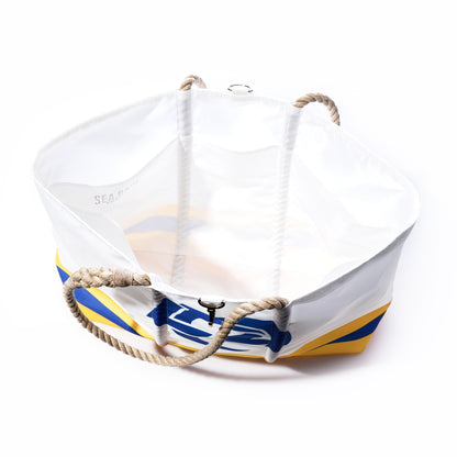 Crafted from recycled sail cloth, the Los Angeles Rams Tailgate Tote by Sea Bags features sturdy rope handles and a striking blue and yellow design on the side. Photographed from above, this spacious tote highlights its roomy interior—ideal for game day essentials or as a stylish accessory at your next tailgate. by Sea Bags