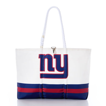 The Sea Bags New York Giants Tailgate Tote is made from recycled sail cloth for enhanced durability and features a bold NY logo on the front, accented with blue and red stripes. With sturdy rope handles and a clasp closure, this versatile tote—shown against a white background—is the perfect accessory for game day or casual outings. by Sea Bags