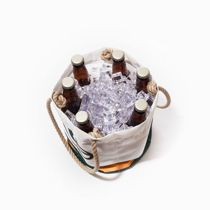 The Sea Bags Green Bay Packers Beverage Bucket features rope handles and holds six brown glass bottles with ice cubes, viewed from above on a white background—a stylish and sustainable cooler for any gathering. by Sea Bags