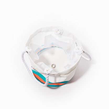 The Miami Dolphins Beverage Bucket by Sea Bags is a white cylindrical tote bag with rope handles, accented by blue and orange stripes. Shown from above on a white background, this stylish and sustainable cooler features a grommet on the bottom and a clear inner pocket—offering both functionality and team pride for your next gathering. by Sea Bags
