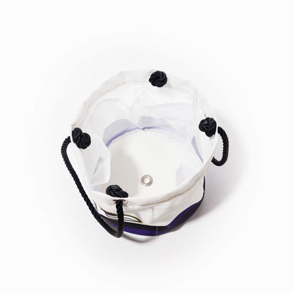 Top view of the Sea Bags Baltimore Ravens Beverage Bucket—an empty white fabric cooler featuring black rope handles with four black knots, a metal grommet at the base, and durable construction—perfect for sustainable beverage storage at your next outing. by Sea Bags