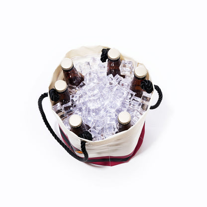 Top view of the Sea Bags Arizona Cardinals Beverage Bucket, a sustainable cooler filled with ice cubes and six brown glass bottles with beige caps, set against a white background. by Sea Bags