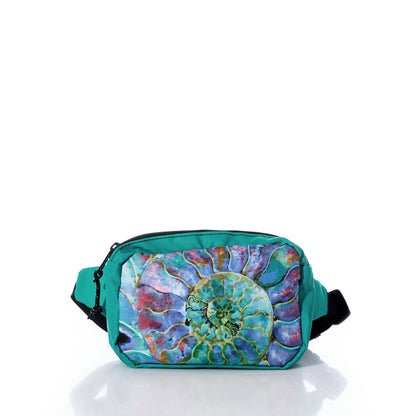 The Sea Bags Multicolor Nautilus Belt Bag features a vibrant nautilus shell design on teal, made from recycled sail cloth. Displayed against a white background with its reflection below, this bag includes an adjustable waistband for a comfortable and secure fit throughout the day. by Sea Bags