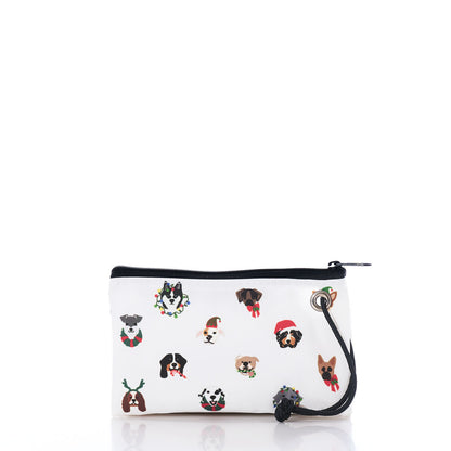 The Very Merry Pups Wristlet by Sea Bags is an eco-friendly, small white zippered pouch featuring a handy wrist strap and adorned with playful cartoon dog faces sporting festive holiday accessories like wreaths, scarves, and Santa hats on a crisp white background. Perfect for dog lovers, this cheerful gift pouch adds a fun and merry touch to everyday essentials. by Sea Bags
