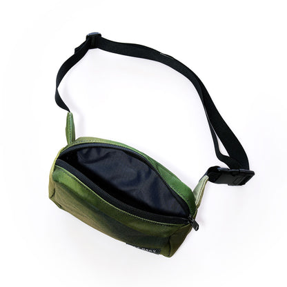 The Sea Bags Dragon Skin Belt Bag features green fabric adorned with a black adjustable strap and buckle. Shown unzipped to display its black interior lining, this sustainably crafted accessory is photographed against a white background. by Sea Bags