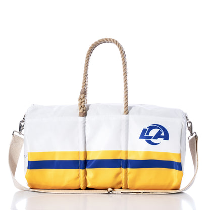 The Los Angeles Rams Duffel by Sea Bags, crafted from recycled sail cloth, features yellow and blue stripes, rope handles, a beige shoulder strap, and the Rams logo on the side. The bag is displayed on a reflective surface. by Sea Bags