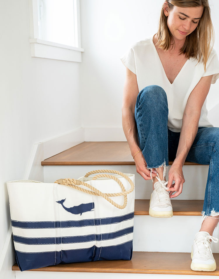 Woman sitting on stairs next to Blue Whale Ogunquit Beach Bag