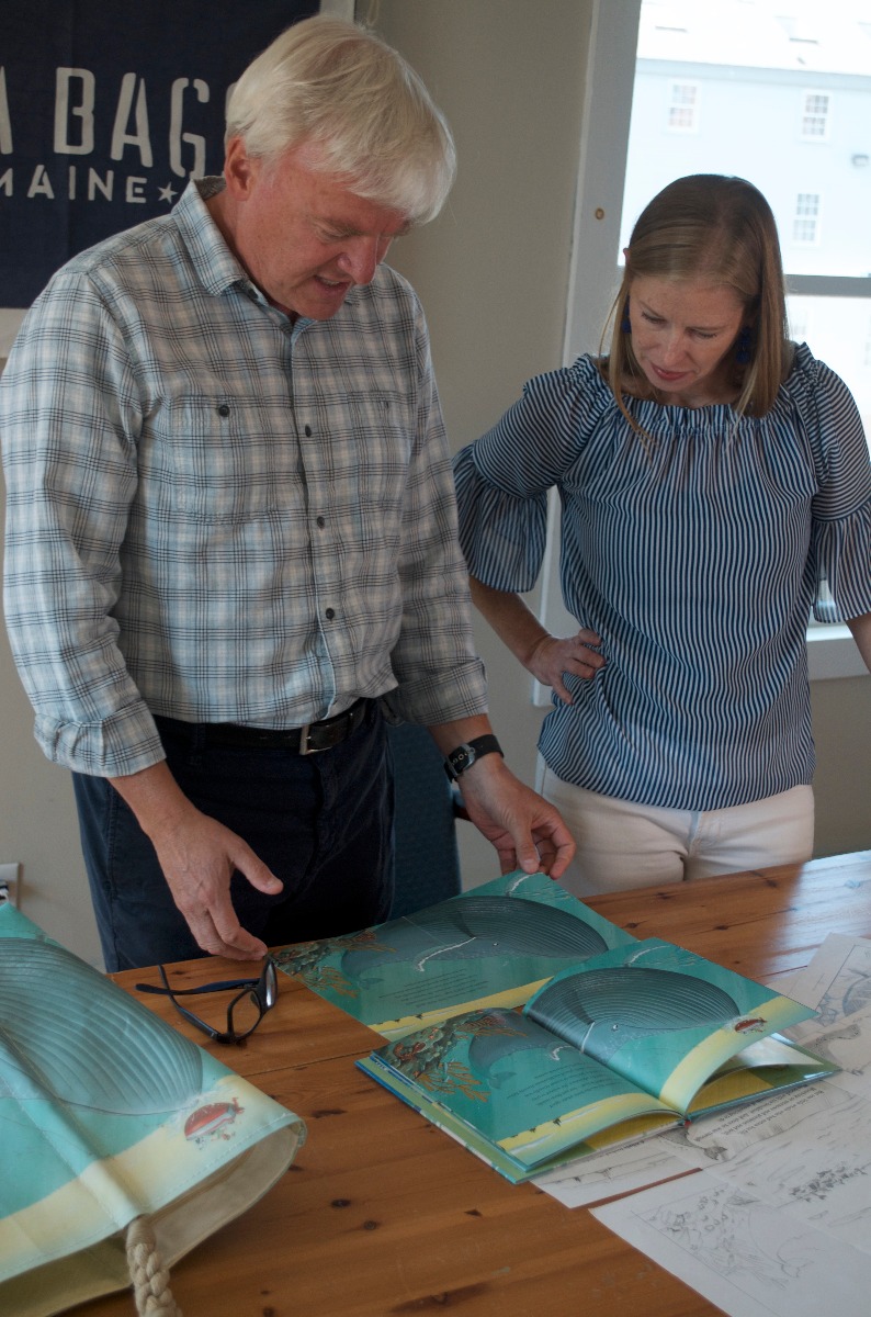 Chris Van Dusen and Sea Bags' Product Line Manager Tara Knupp look at the finished design on a recycled sail cloth tote