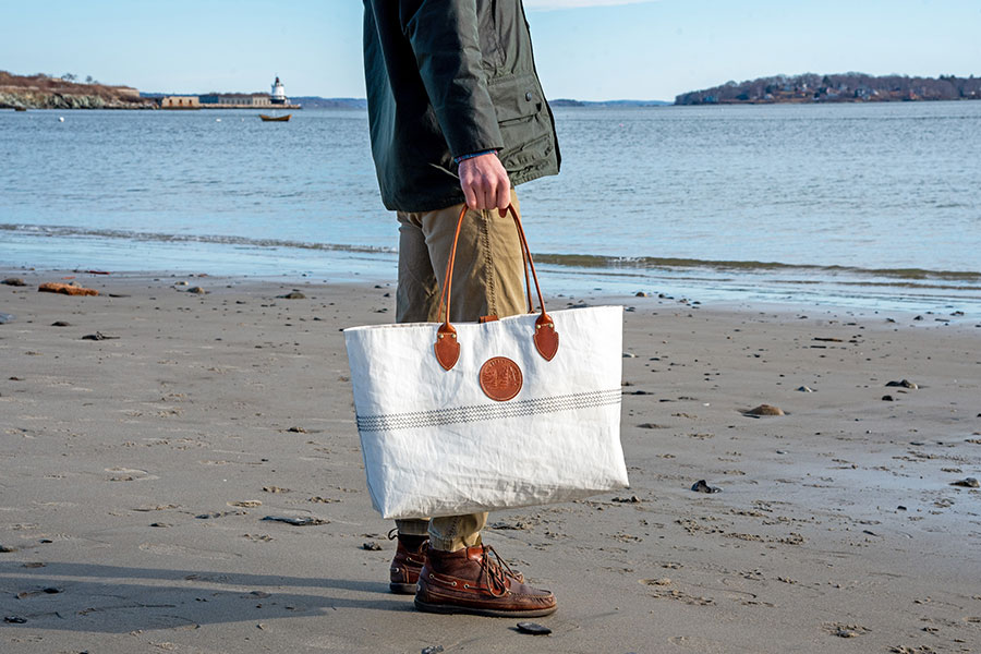 Man holding Sea Bags Heritage Tiziana Tote on a beach