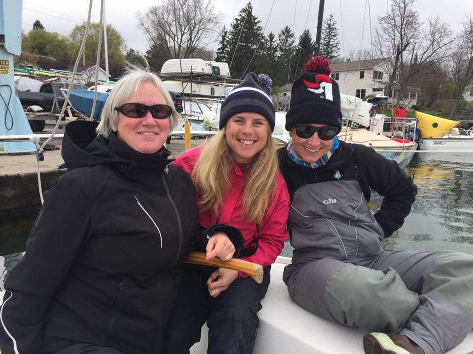 Members of the Sea Bags Women's Sailing Team wait for wind aboard their J/24 sailboat