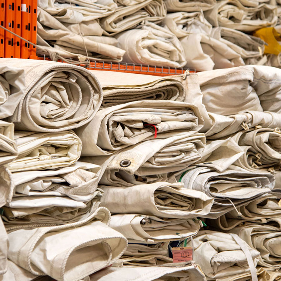 Stacks of sails to be processed, cut and made into Sea Bags