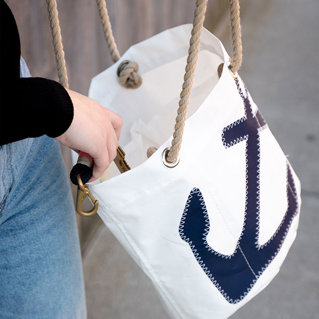 Woman putting phone inside Navy Anchor Essential Handbag