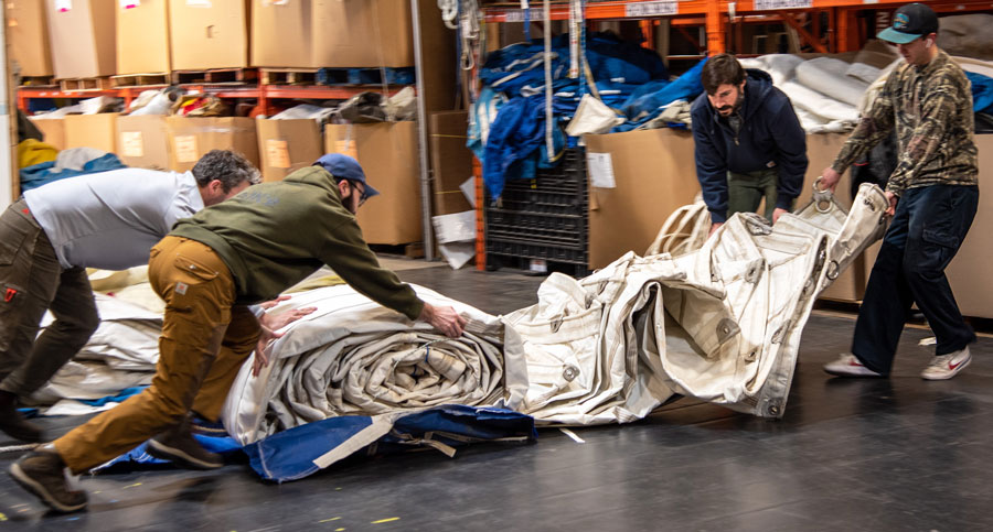 Sea Bags workers unraveling a large sail