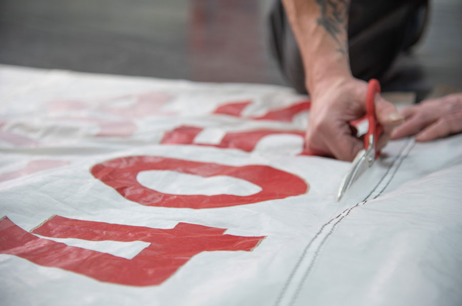 Worker cutting a vintage sail into panels