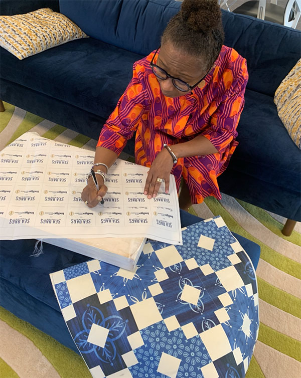 Marcia Minter signing patches to be sewn into each Indigo Rising Tote.
