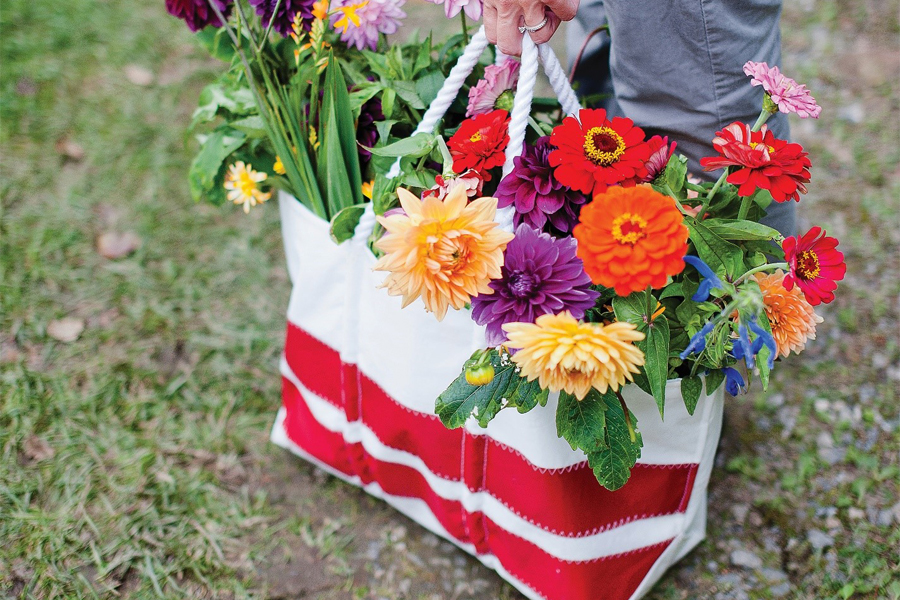 Vintage Sea Bags tote made from recycled sail cloth serves as a carrier for bundles of flowers.