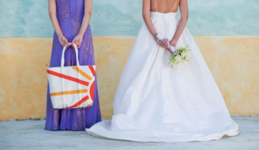 A bride and her maid of honor stand side by side, with a Custom Design Tote in the maid of honors hands.