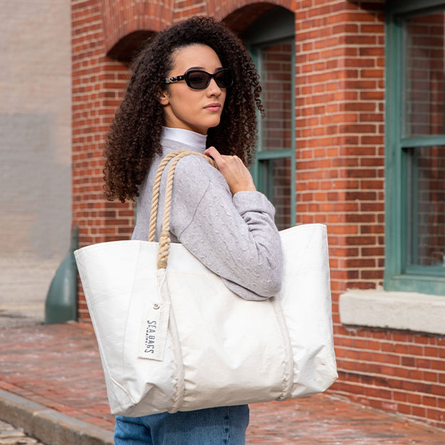 Wharf Tote worn by model in front of brick building