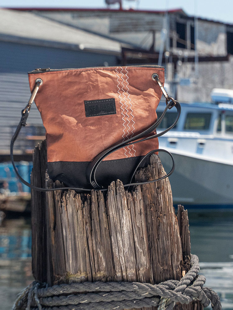 NEW Heritage Tanbark Crossbody on a pier near fishing boats