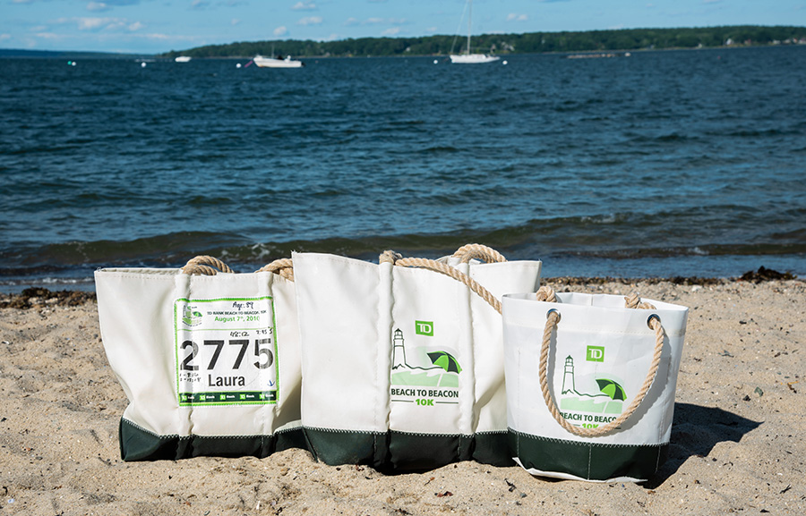 TD Beach to Beacon Sea Bags tote, beverage bucket, and race tote on the beach in Maine