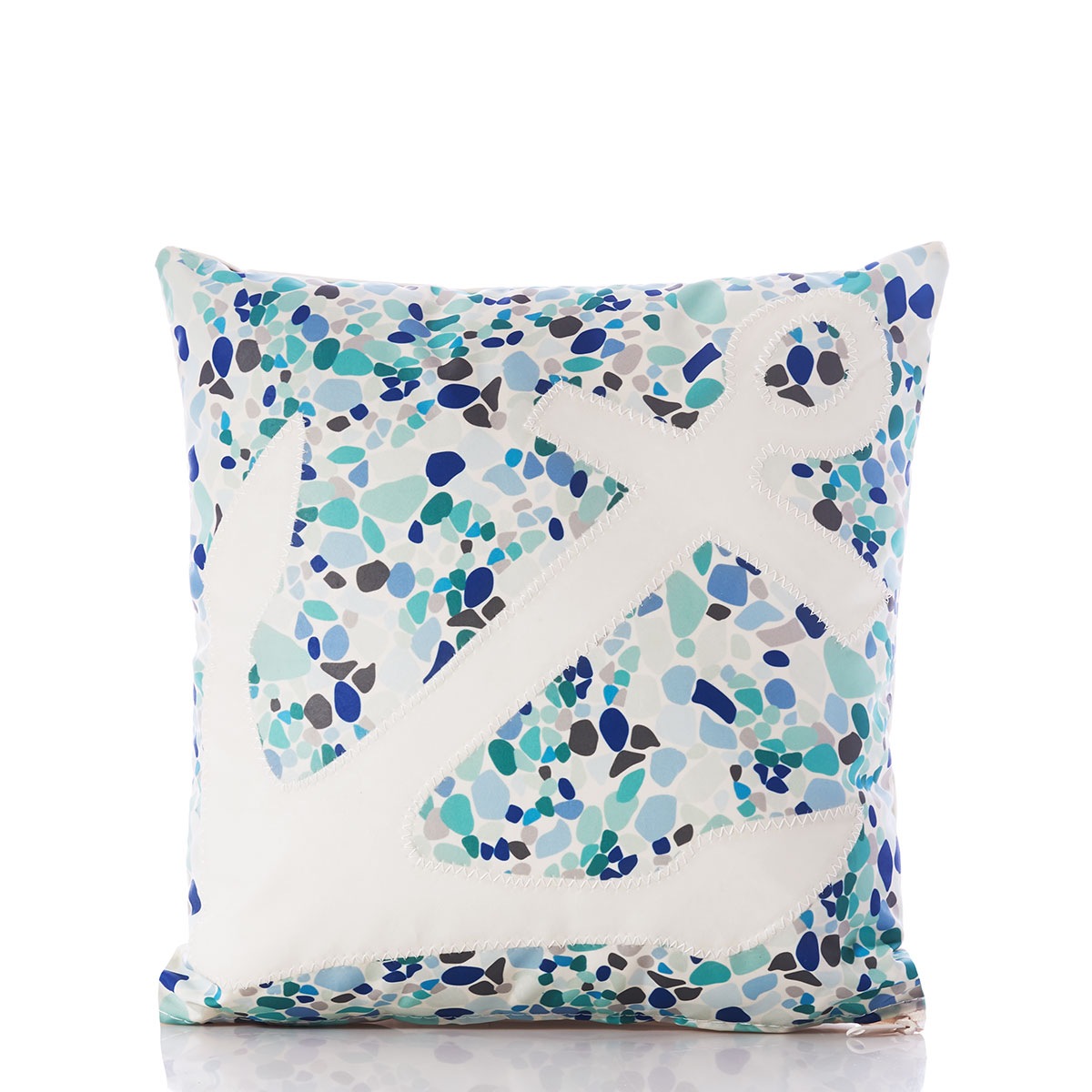 a white anchor sits on the front of a recycled sail cloth pillow covered in a sea glass print of varied blues