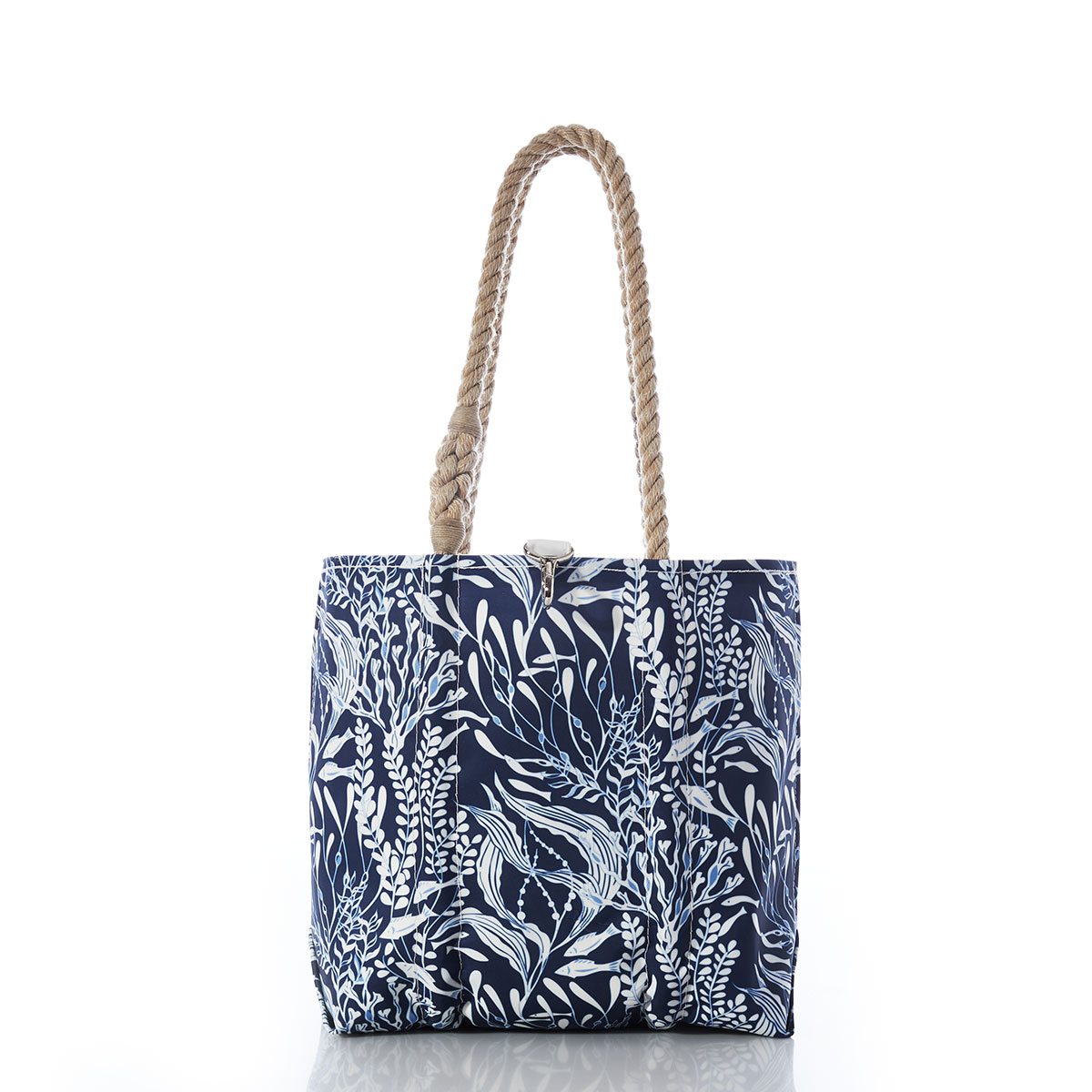 little fish swim among various types of seaweed in shades of navy and white on a recycled sail cloth handbag with hemp rope handles