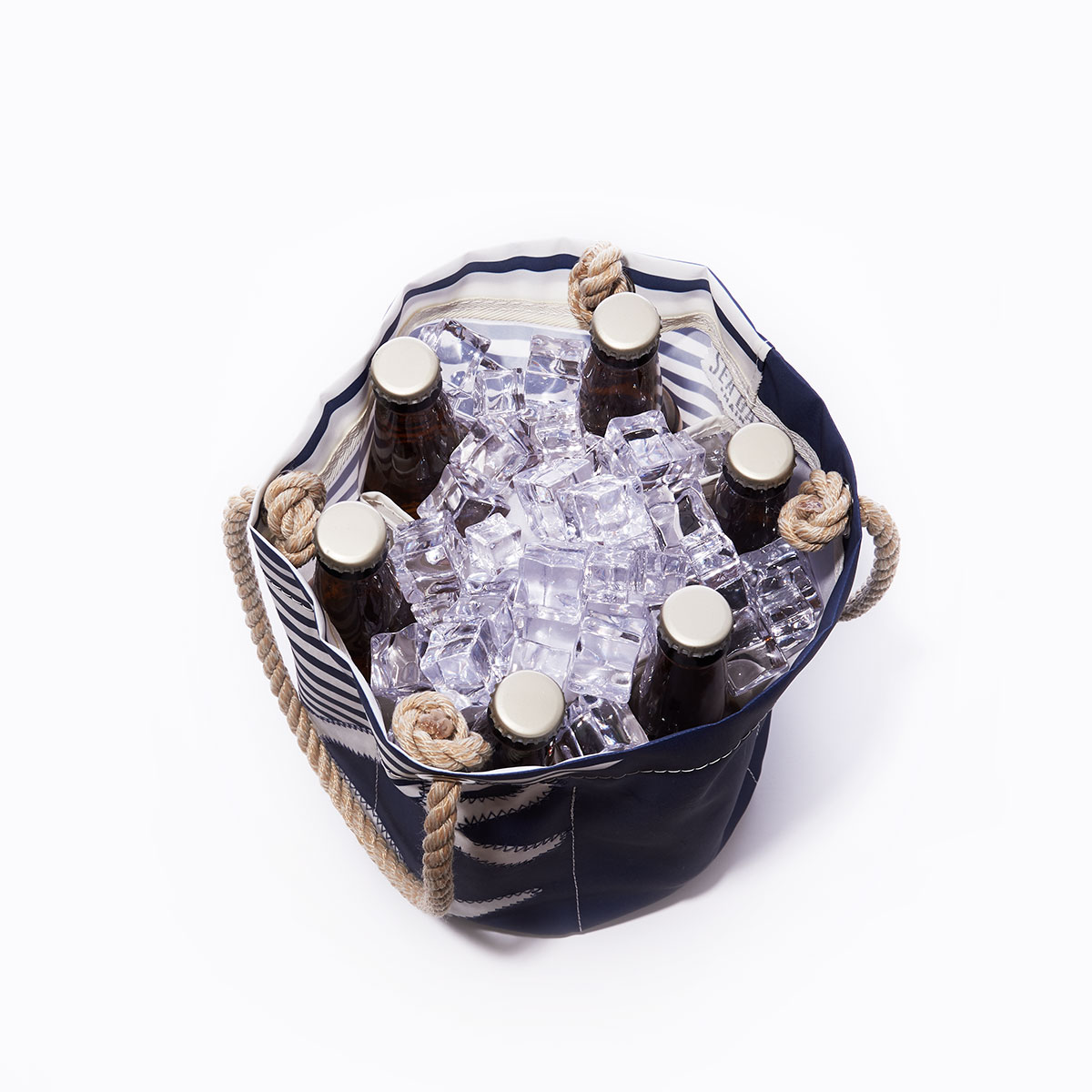inside view with bottles and ice: the breton stripe white anchor beverage bucket is embellished with a white anchor in front of a solid navy bottom corner and a navy and white striped top corner and navy rope handles