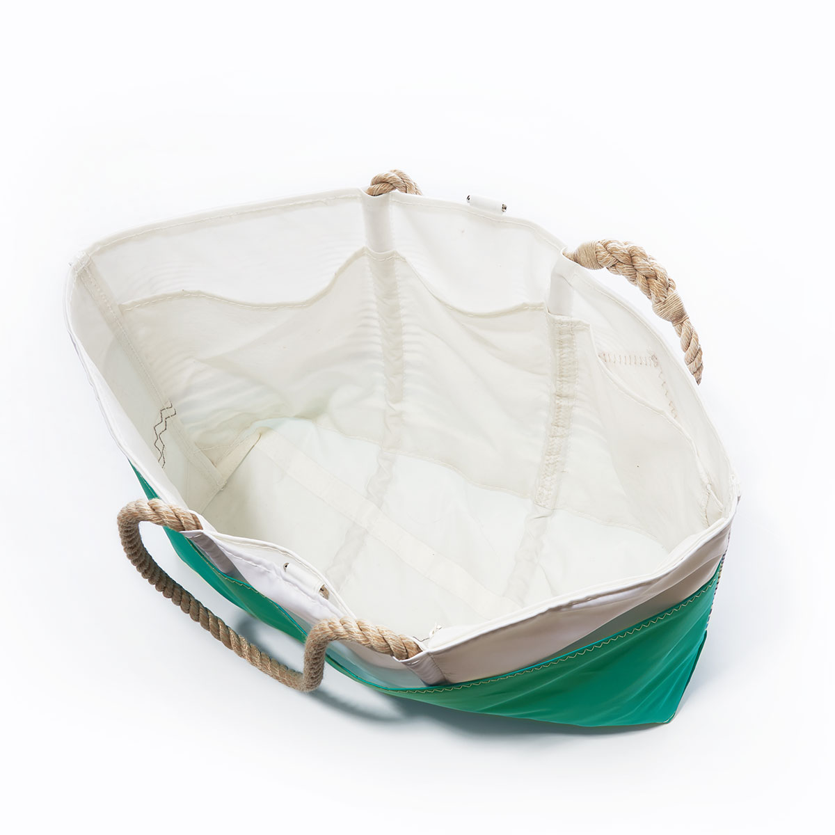 inside view of a recycled sail cloth beach tote with hemp rope handles is printed with ombre stripes of blue into green with a solid green bottom