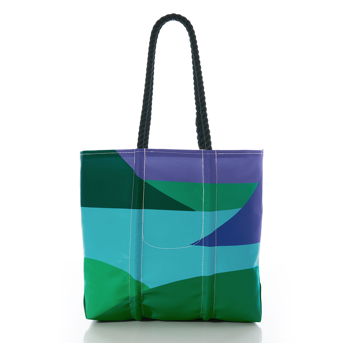 back view of a geometric landscape of blue water and green and navy mountains with a lone blue sailboat printed on a recycled sail cloth tote with hemp rope handles
