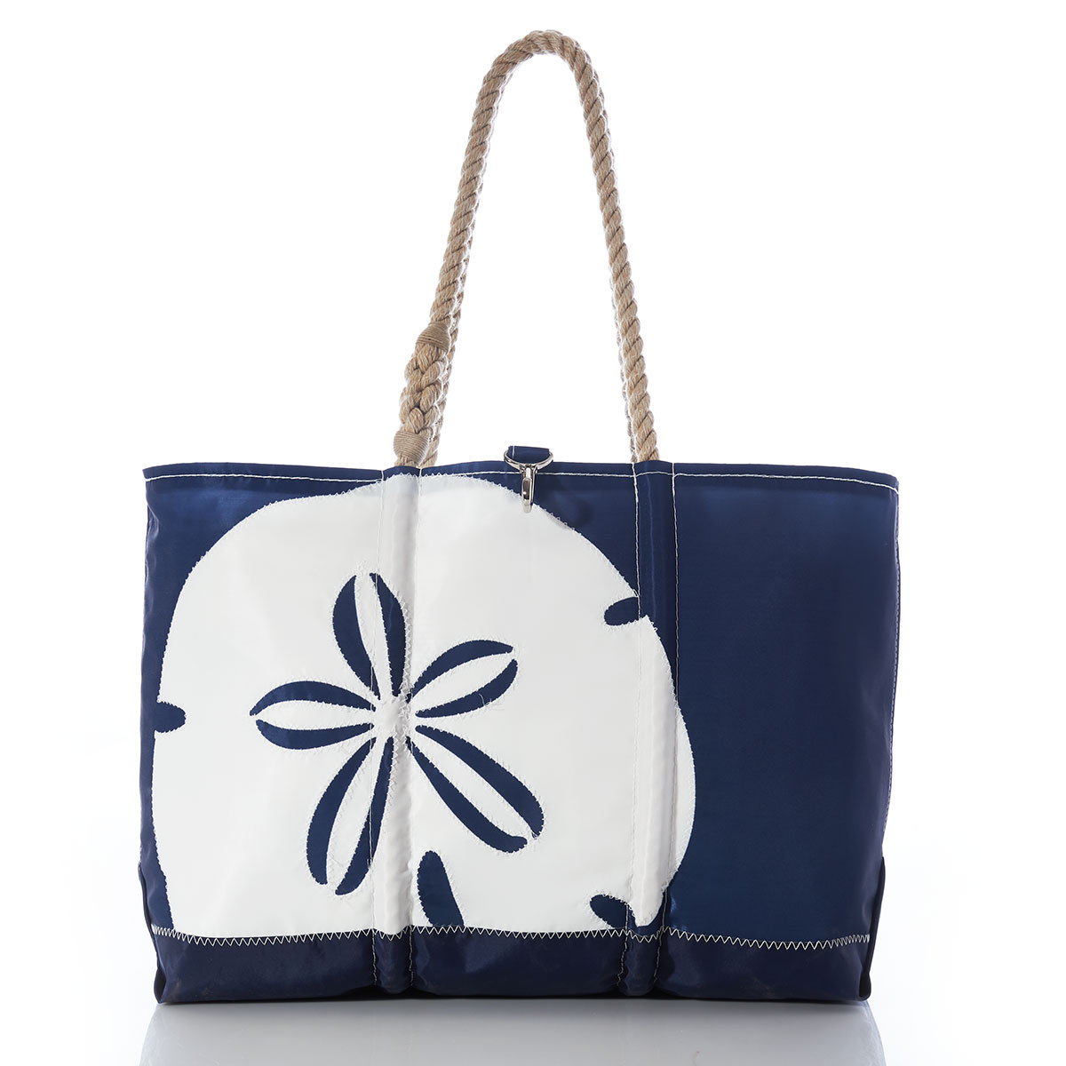 a navy recycled sail cloth ogunquit beach bag with hemp rope handles is embellished with a white sand dollar