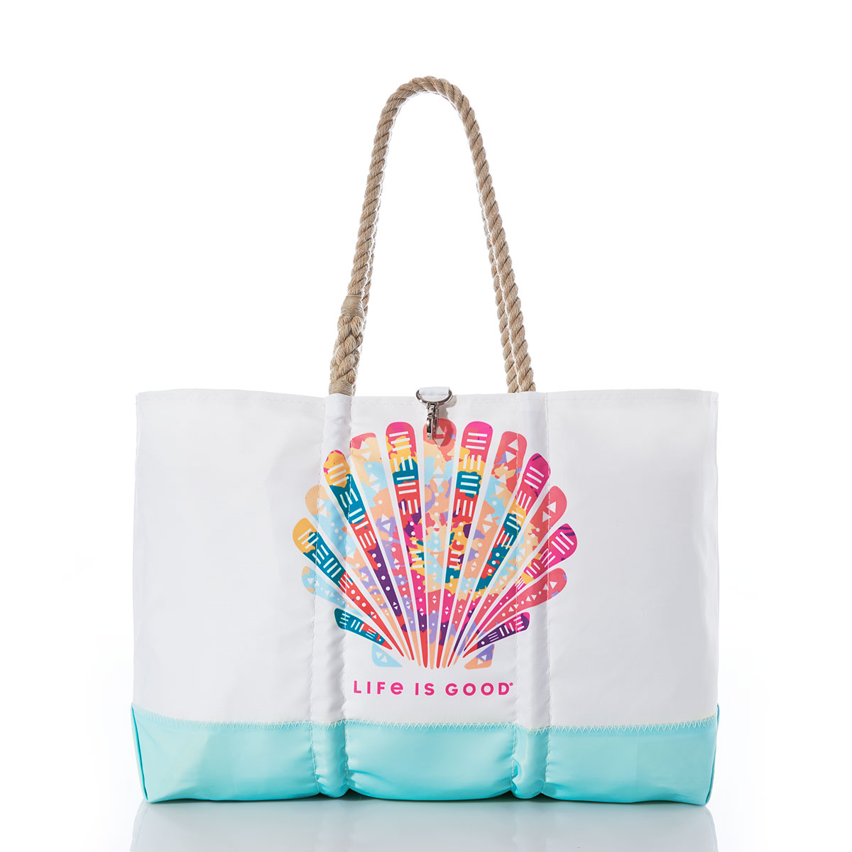 a white recycled sail cloth beach tote with hemp rope handles and a teal bottom is printed with a bright neon pink shell over the words Life is Good