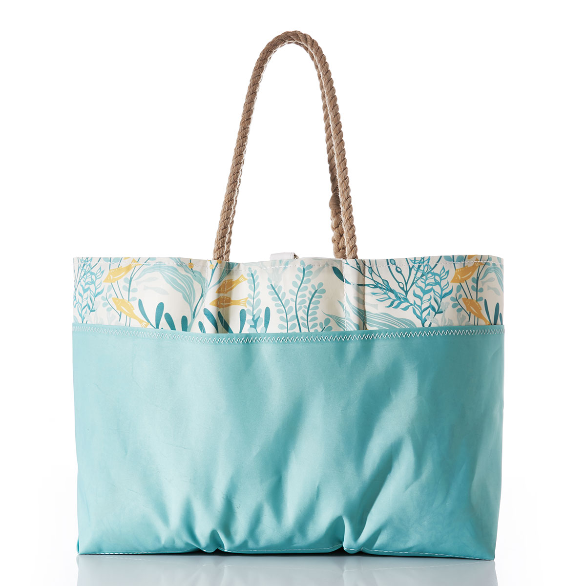 back view showing seafoam green outer pocket: little yellow fish swim among various types of seaweed in shades of blue on a white recycled sail cloth tote with a seafoam green covering the bottom of the bag