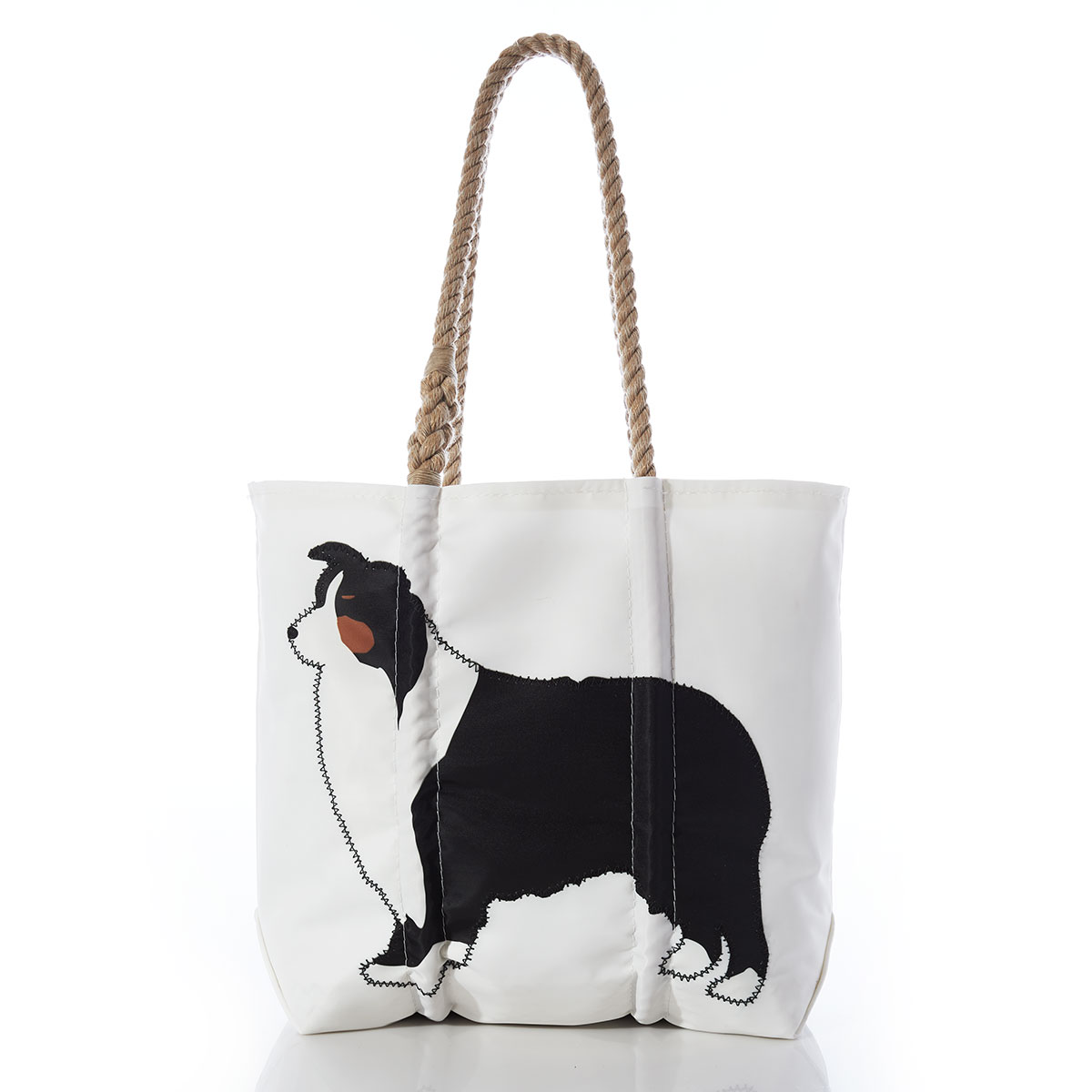 a black brown and white colored Australian Shepard dog is printed on a white recycled sail cloth tote with hemp rope handles
